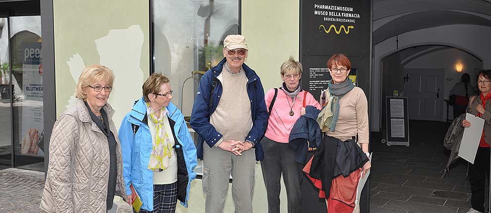 Gruppe von begeisterten Senioren vor dem Eingang des Museums
